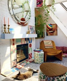 a living room filled with furniture and a fire place next to a stair case covered in plants