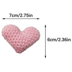 a pink crocheted heart on a white background with measurements for the size and width