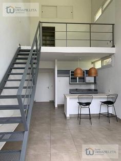 an open floor plan with stairs leading up to the kitchen