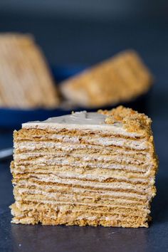 a piece of cake sitting on top of a table next to a blue bowl and fork