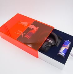 an open box with headphones and a tube in it on a white table top