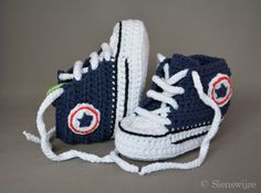 a pair of crocheted shoes with white laces on the bottom and blue soles