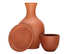 a brown vase and two cups on a white background