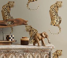 an elephant and some cheetah wall decals on a dresser in a living room