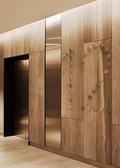 an elevator in a building with wooden panels and metal doors on the wall, along with wood flooring