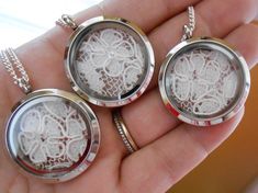 three lockes with white lace on them are being held in someone's hand