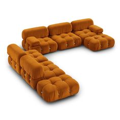 an orange couch sitting on top of a white floor next to a chair and ottoman