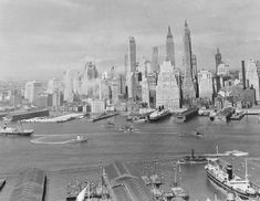 an old black and white photo of a harbor with ships in the water near large city buildings