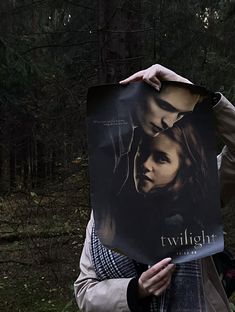 a man holding up a poster with the twilight saga on it