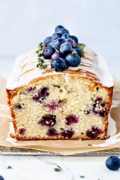 a loaf of blueberry pound cake with icing and fresh berries on top