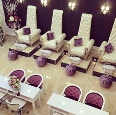 the salon is decorated with white chairs and purple bows on their armrests,