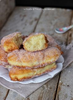 some sugared doughnuts are stacked on top of each other and ready to be eaten