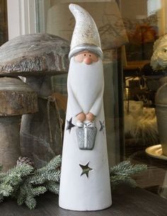 a white gnome figurine sitting on top of a wooden table