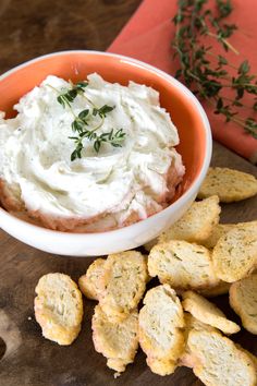 a bowl filled with whipped cream next to crackers