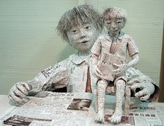 two paper mache figures sitting on top of a table