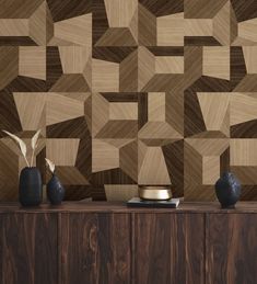 two vases are sitting on a wooden shelf in front of a geometric wallpaper