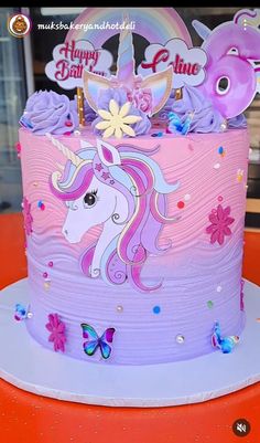 a pink and purple birthday cake with an unicorn on top