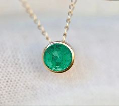 Genuine earth mined emerald tourmaline set in 14k gold. Stone Size : 4mm Necklace Length : see options Metal : 14k Gold Gemstone : Earth Mined Emerald Packaging : All products purchased from us come in a gift box. If you need to include a message, kindly leave us a note when purchasing. Care Recommendations: When not in use, keep earrings enclosed in a box or pouch to minimize exposure to moisture in air. Do not spray aromatics directly onto product. Minimize exposure to water. Clean with a soft Minimalist Emerald Necklace In Yellow Gold, Minimalist 14k Gold Emerald Gemstone Necklace, Minimalist 14k Gold Emerald Necklace, Minimalist Yellow Gold Emerald Necklace, Dainty Round Emerald Necklace, Minimalist Round Emerald Necklace For May Birthstone, Dainty 14k Gold Round Emerald Necklace, Round Emerald Necklace In 14k Gold Bezel Setting, Round Bezel Set Emerald Necklace In 14k Gold