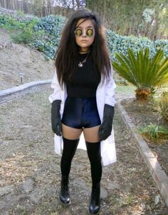 a woman in short shorts and knee high socks standing on the side of a road