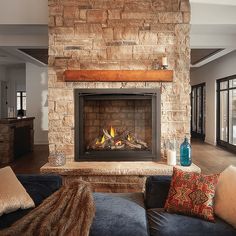 a living room filled with furniture and a fire place in the middle of it's fireplace