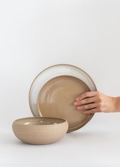 a person holding a plate next to a bowl