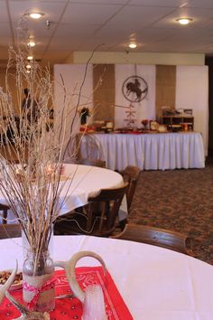 the table is set up for an event with flowers in vases and utensils