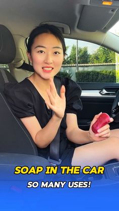 a woman sitting in the back seat of a car holding an apple