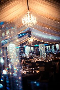 an image of a wedding tent with chandelier and tables set up for the reception