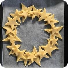 some yellow stars are arranged in the shape of a wreath on top of a baking sheet