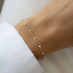 "Delicate bracelet featuring white enamel colored beads. This is an dainty and chic bracelet to add a pop of color to any outfit or look. Great for summer! Also available as anklet :) - - - D E T A I L S - - - * Made of 925 Sterling Silver * 14k Gold or Rhodium plated. We use a THICK plating for a high-quality piece that will be with you for years to come. * Available Lengths: 6.25\", 6.75\" or 7\" + 0.5\" ext * Nickel-free and Hypoallergenic * Lobster Clasp Closure * White Enamel Colored Beads Also Available in Turquoise Beads: https://www.etsy.com/listing/1516228791/turquoise-beaded-bracelet-by-sami-jewels?click_key=7b73700d9674ee3386613ee1ce0870e0b93daa54%3A1516228791&click_sum=b785a2b0&ga_search_query=turquoise&ref=shop_items_search_2&pro=1&frs=1&sts=1 Also Available as an Anklet Not s Minimalist Beaded Bracelets With Satellite Chain, Minimalist Chain Bracelet With Tiny Beads, Dainty Beaded Bracelet With Extender For Everyday, Dainty Beaded Bracelet For Everyday, Modern White Jewelry With Delicate Chain, Minimalist White Beaded Bracelets For Everyday, White Minimalist Jewelry With Satellite Chain, White Pearl Bracelet With Delicate Chain, Minimalist White Jewelry With Satellite Chain