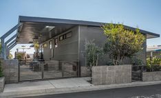 a small house with a metal roof and fence