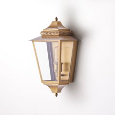 a wall mounted light on the side of a white wall next to a lamp post