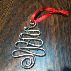 a metal christmas tree ornament on a wooden table