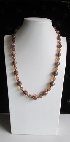 "This necklace features graduated lampworked brown glass beads. These beads have small pink/white roses with green leaves. In between these beads are small brown bicone and larger round Austrian crystal beads. The clasp, extension and remaining findings are sterling silver. Lampwork beads are made by melting narrow rods of glass by hand over an open flame. The glass is wrapped around a mandrel, a thin metal rod, which later becomes the hole through the bead. The necklace has a 1\" extension with Shamrock Earrings, Sterling Silver Anklet, Sterling Bracelets, Rose Necklace, Silver Anklets, Lovely Earrings, Body Jewellery, Pink Crystal, Jewelry Inspo