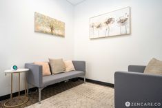 an office waiting room with two couches and a table