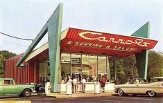 an old photo of cars parked in front of a car dealership with people standing outside