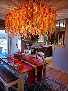 a dining room table with chairs and a chandelier hanging from it's ceiling