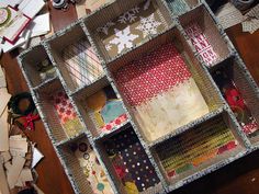 an assortment of crafting supplies are arranged on a wooden table with paper and scissors