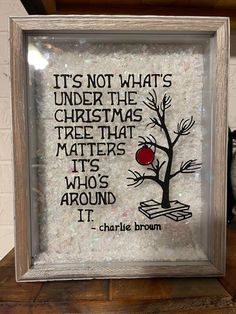 a glass frame with an image of a tree and the words it's not what's under the christmas tree that matters