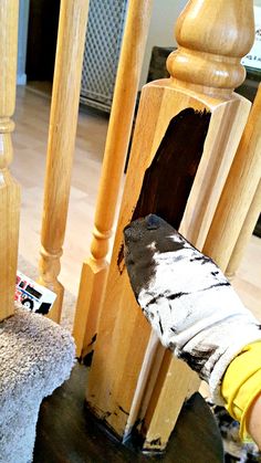 a person is removing wood from the top of a wooden chair with a cloth on it