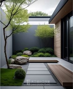 a garden with rocks, grass and trees in the middle of it's walkway