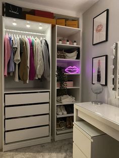 an organized closet with clothes and shoes on the shelves in front of a vanity table