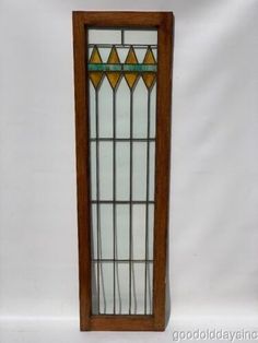 an old stained glass window with wooden frame on white background, it appears to be in good condition