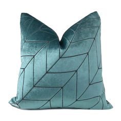 a blue pillow with an intricate design on the front and back, sitting on a white surface