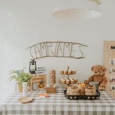 a teddy bear sitting on top of a table next to cupcakes and cookies