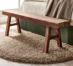 a wooden bench sitting on top of a shaggy rug