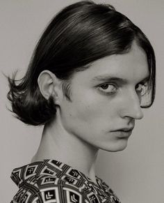 a black and white photo of a woman's face with hair in a bun