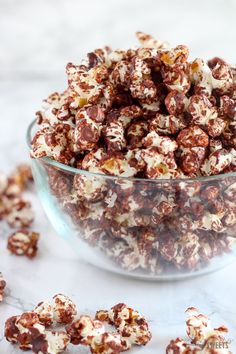 a glass bowl filled with chocolate covered popcorn