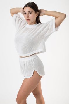 Featuring a classic mock neck silhouette and oversized fit, this crop top has a beachy nostalgic feel. Our cotton mesh fabric is knit locally to be breathable and lightweight, making it a universal summer staple. For a monochromatic look, we recommend wearing the RIN304GD Cotton Fishnet Shorts in a matching color. This item can also be layered with any of our swimsuits, intimates, performance wear, or bodysuits. Great for lounging, sleeping, water activities, working out, and sweating. | Cotton Fishnet Shorts, Fishnet Crop Tops, Los Angeles Apparel, Garment Manufacturing, Blue Black Color, Mid Length Sleeves, Performance Wear, Crop Shirt, Black Crop Tops