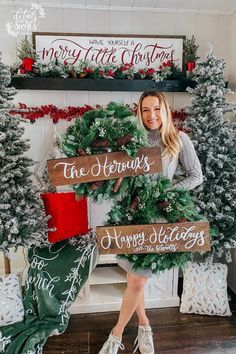 a woman standing in front of christmas wreaths with the words merry little christmas on them